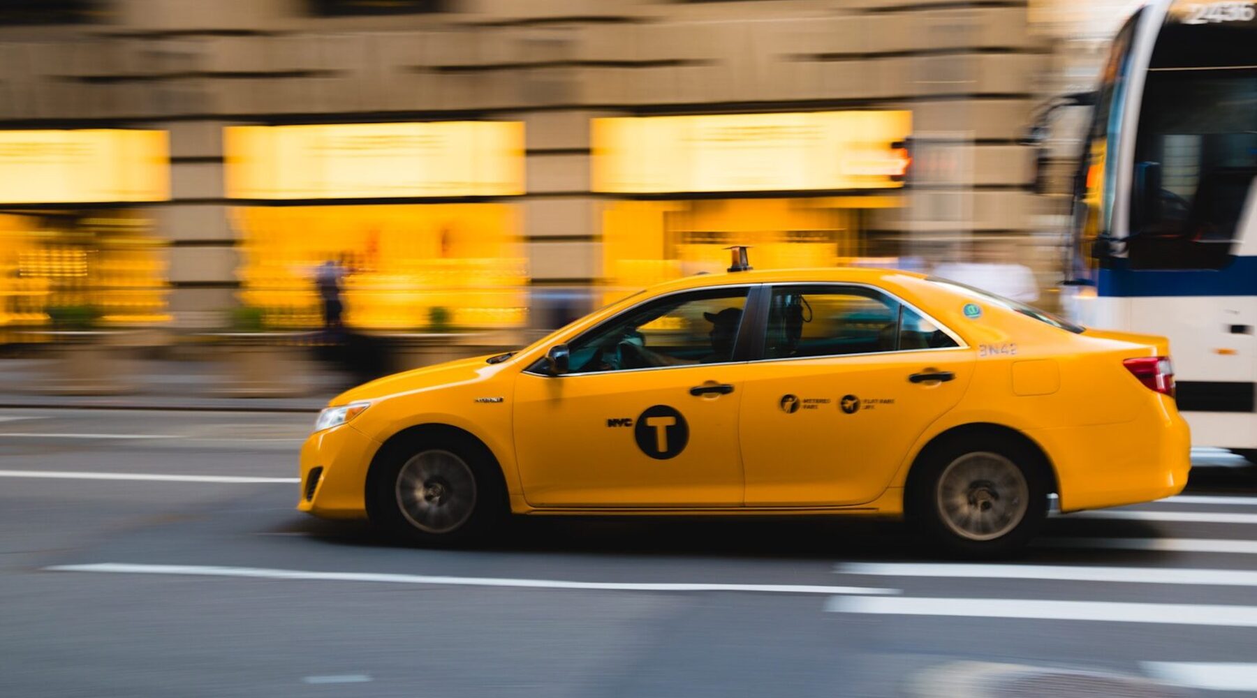 tilt shift photography of yellow taxi car